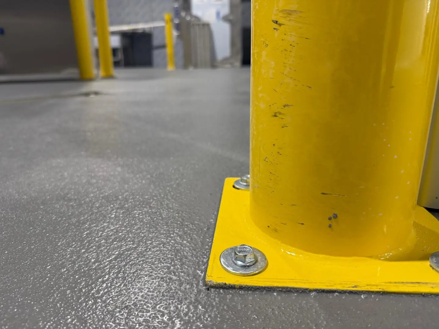 Industrial gray epoxy floor with yellow guard rail, South Florida