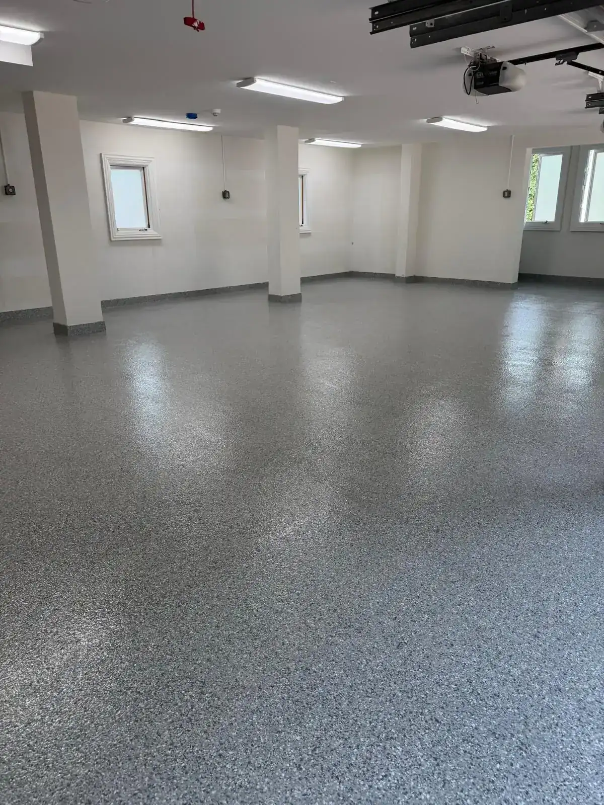 Residential garage with gray flake flooring and columns, Sunrise FL