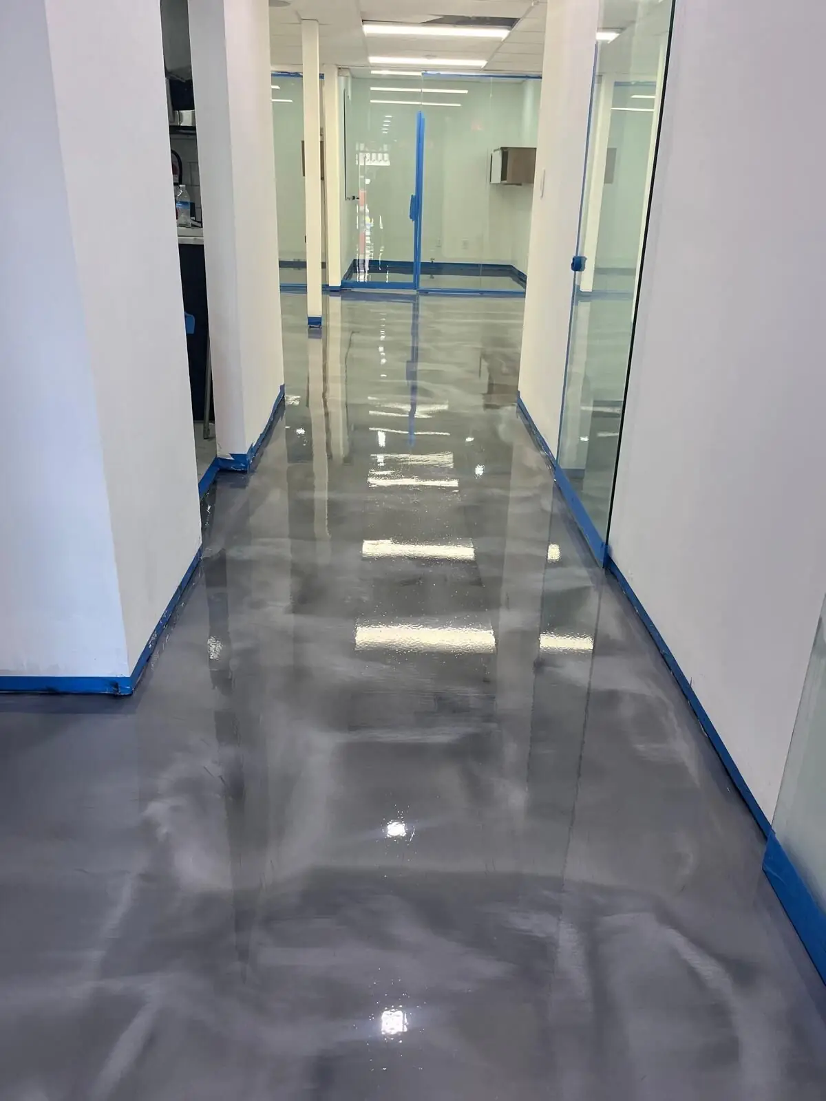 Commercial hallway with a glossy gray metallic floor, South Florida