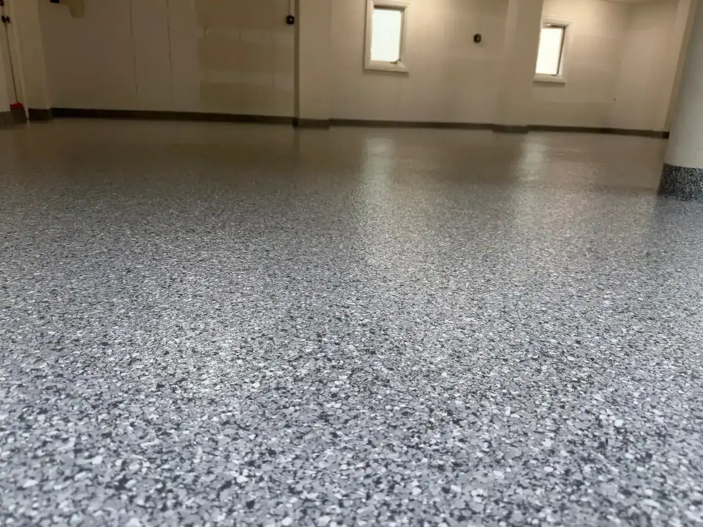Close-up of a gray and white flake floor with a glossy finish